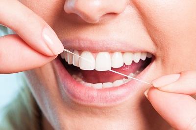 close up of woman flossing teeth l dentist armidale 