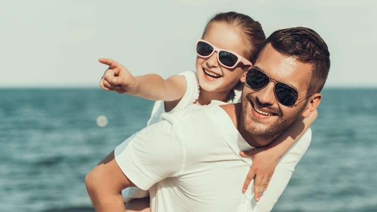Father and daughter enjoying the beach in Armidale with their healthy teeth