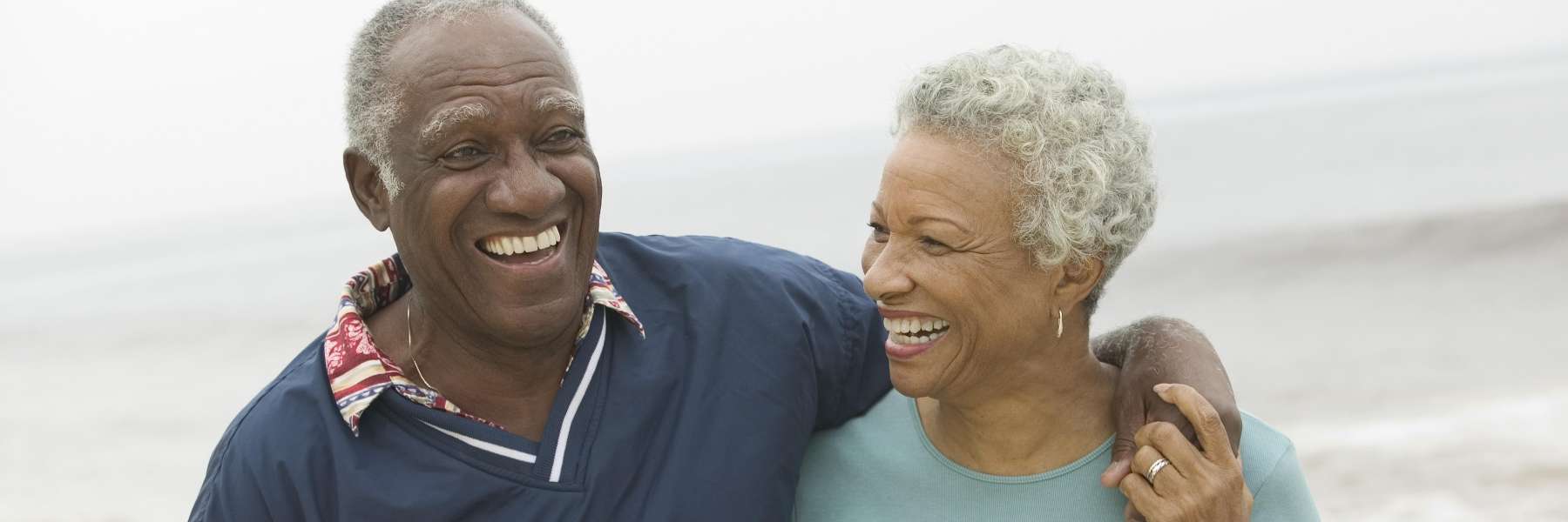 Older couple smiling at the beach